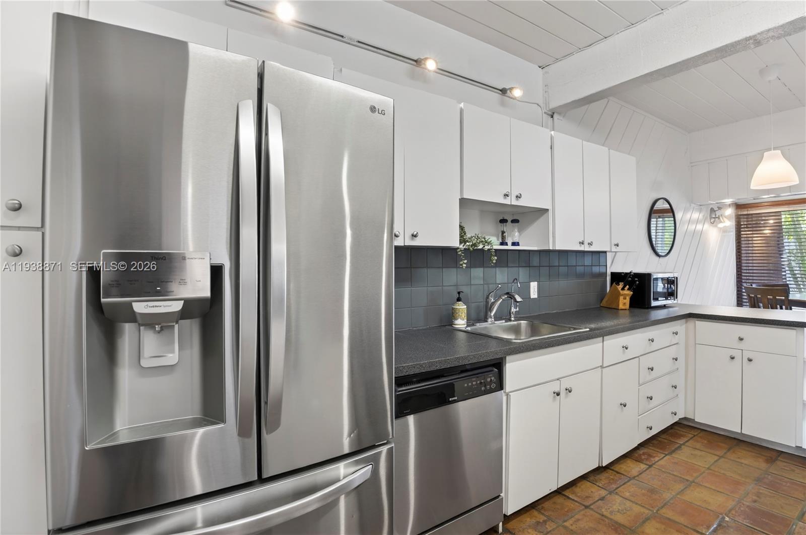 7673 Southwest 103rd Place Miami, FL 33173 - Photo 7 of 20 a kitchen with stainless steel appliances a refrigerator sink and cabinets