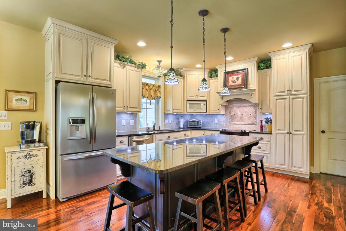 369 Nottingham Road Quarryville, PA 17566 - Photo 22 of 57 a kitchen with stainless steel appliances granite countertop table chairs refrigerator and sink