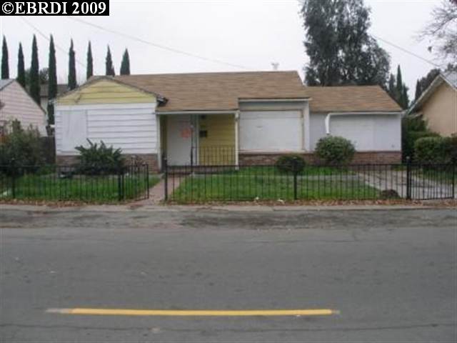 a front view of a house with a garden and plants
