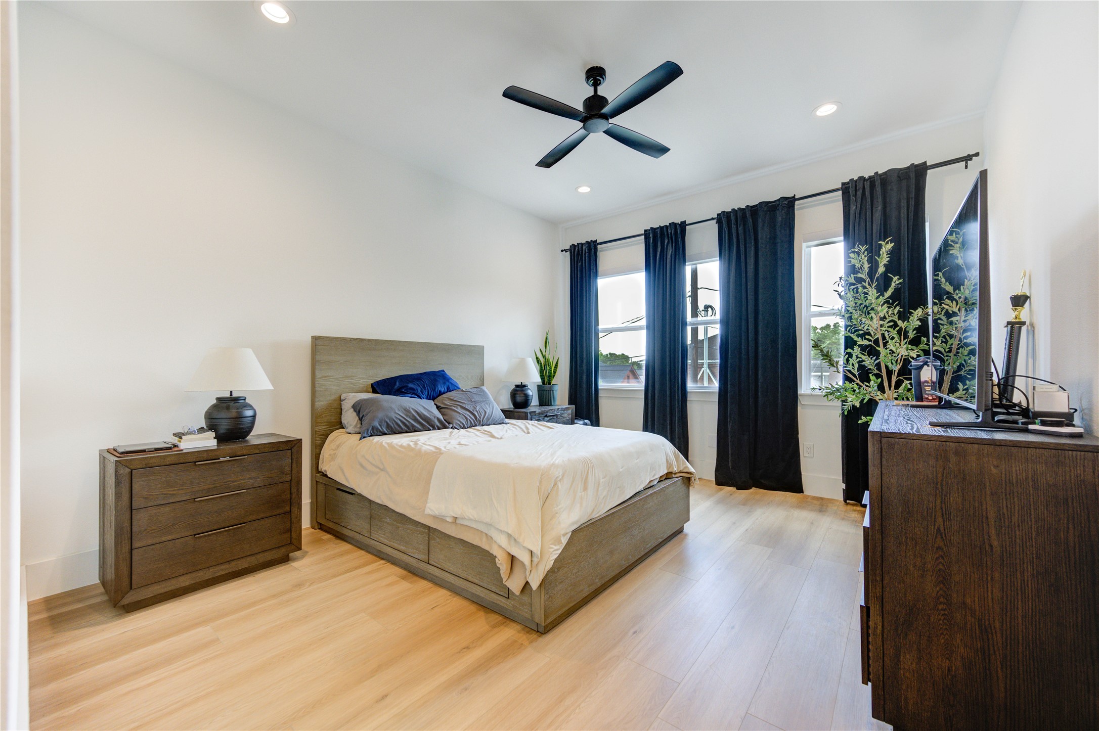 18 Sidney Street, Unit A Houston, TX 77003 - Photo 16 of 30 a spacious bedroom with a large bed chandelier and a window