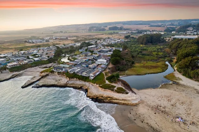 a view of a patio with a table and chairs under an umbrella next to a yard