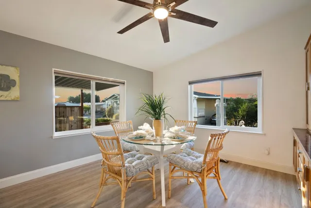 a kitchen with stainless steel appliances granite countertop a sink a stove a refrigerator cabinets and living room view