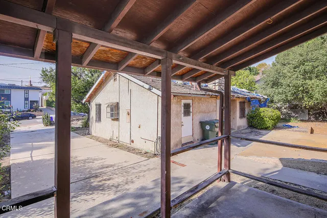 a view of a small house with wooden fence