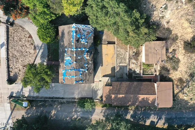 an aerial view of a house with a yard and large trees