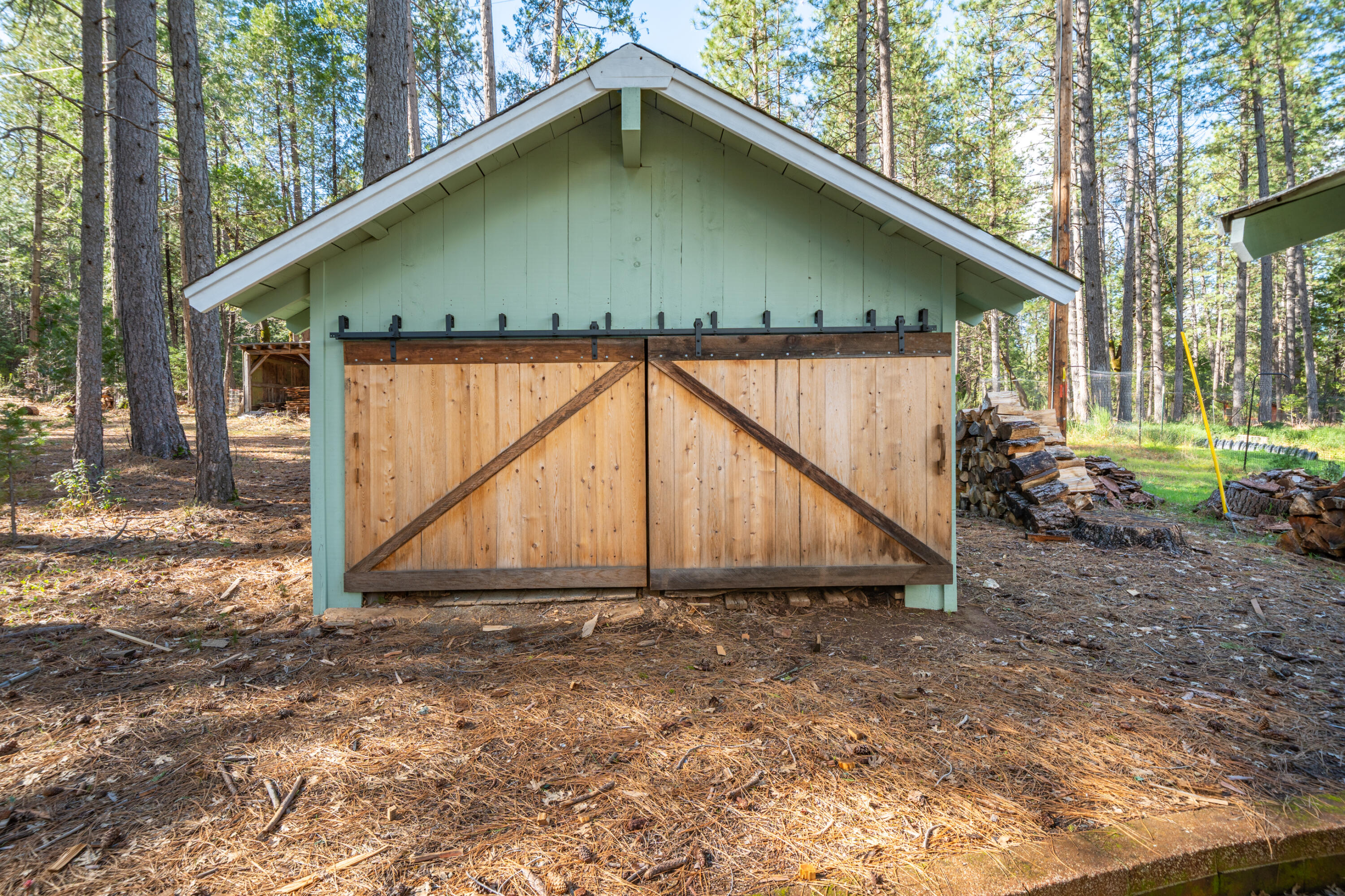 29276 Bullskin Ridge Road Oak Run, CA 96069 - Photo 66 of 113 a backyard of a house with large trees and wooden fence
