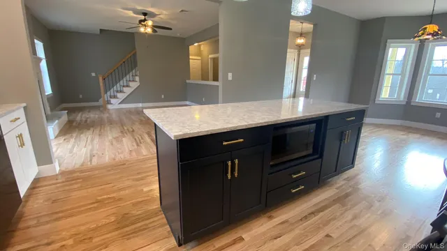 a kitchen with granite countertop a sink cabinets and wooden floor