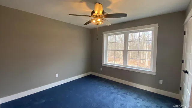 an empty room with a window and a fan