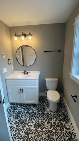 a bathroom with a toilet sink and mirror