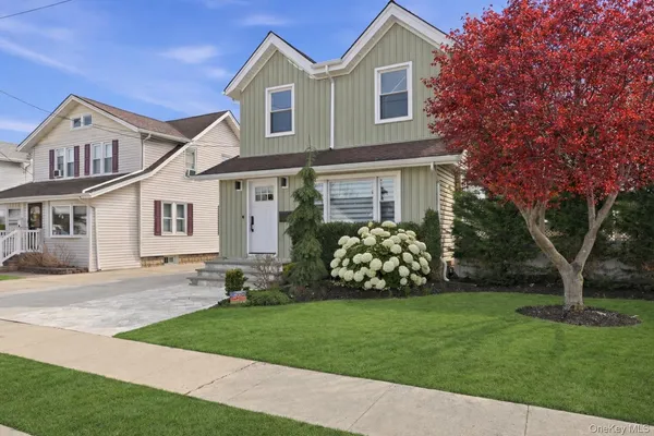 a front view of a house with a garden and yard