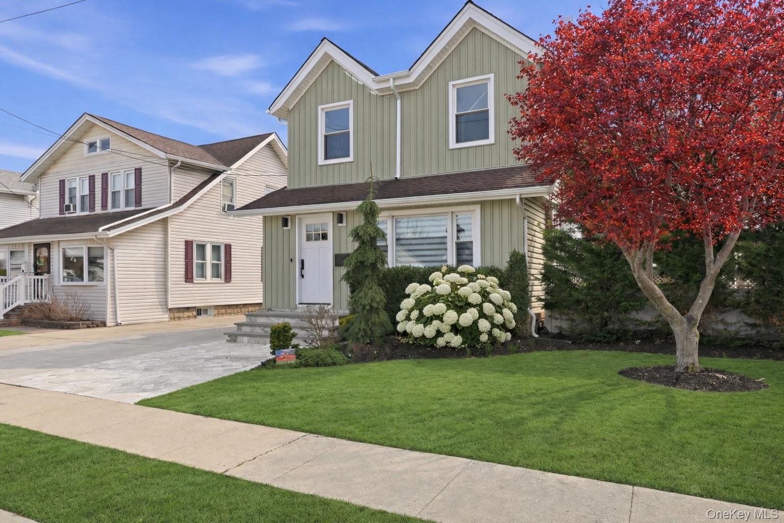 98 Vincent Place Lynbrook, NY 11563 - Photo 1 of 1 a front view of a house with a garden and yard