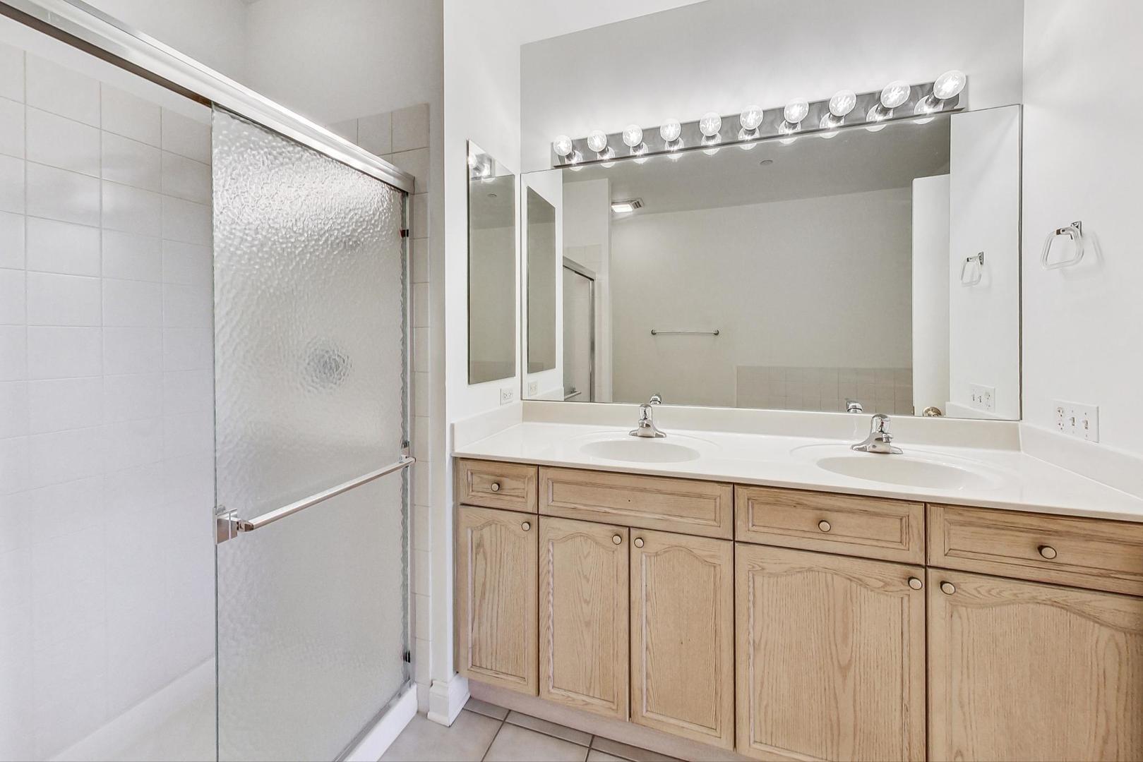 620 McHenry Road, Unit 407 Wheeling, IL 60090 - Photo 13 of 23 a bathroom with a double vanity sink and a mirror