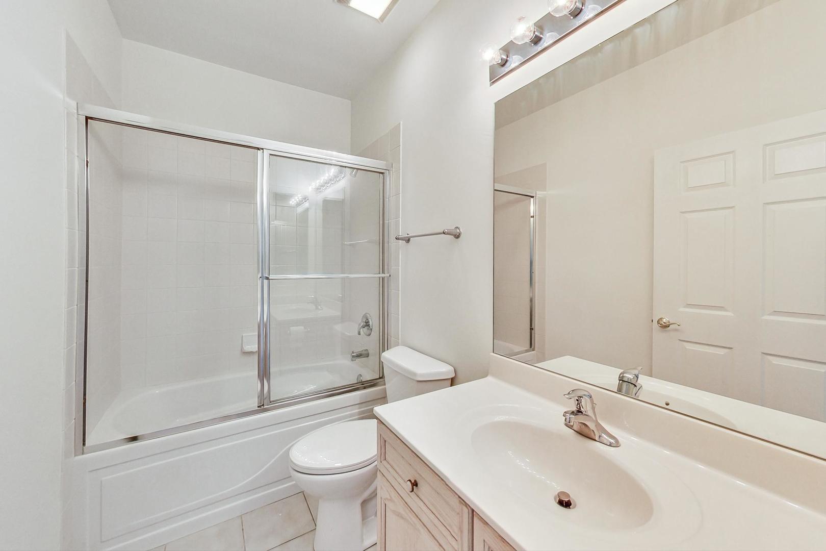 620 McHenry Road, Unit 407 Wheeling, IL 60090 - Photo 19 of 23 a bathroom with a sink a toilet and shower