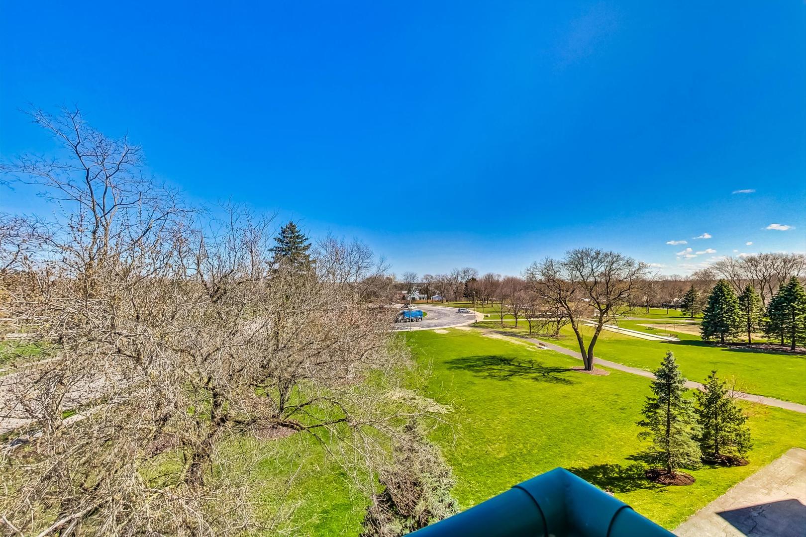 620 McHenry Road, Unit 407 Wheeling, IL 60090 - Photo 22 of 23 a view of a lake with houses in the background