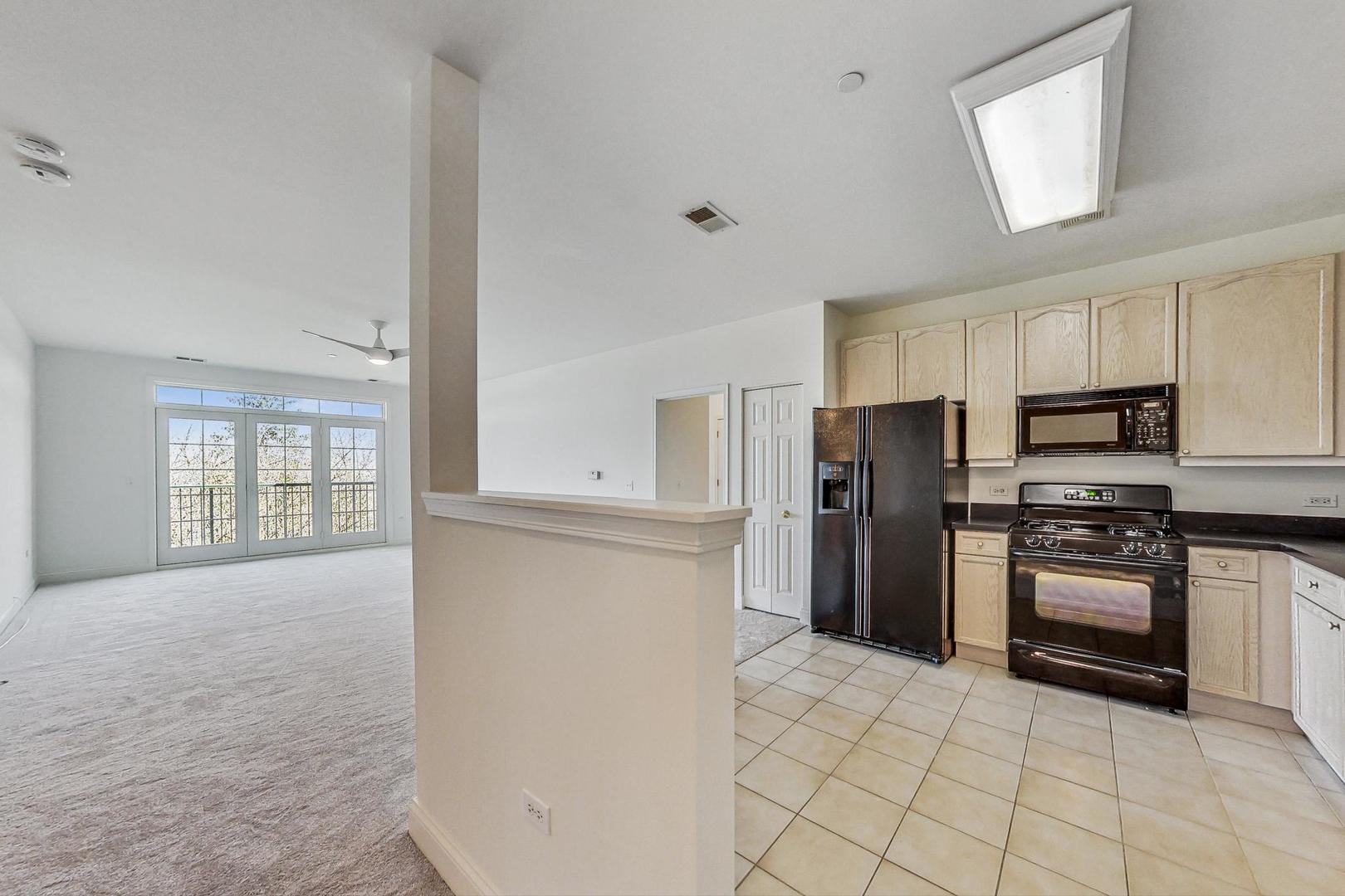 620 McHenry Road, Unit 407 Wheeling, IL 60090 - Photo 4 of 23 a kitchen with stainless steel appliances a refrigerator stove and microwave