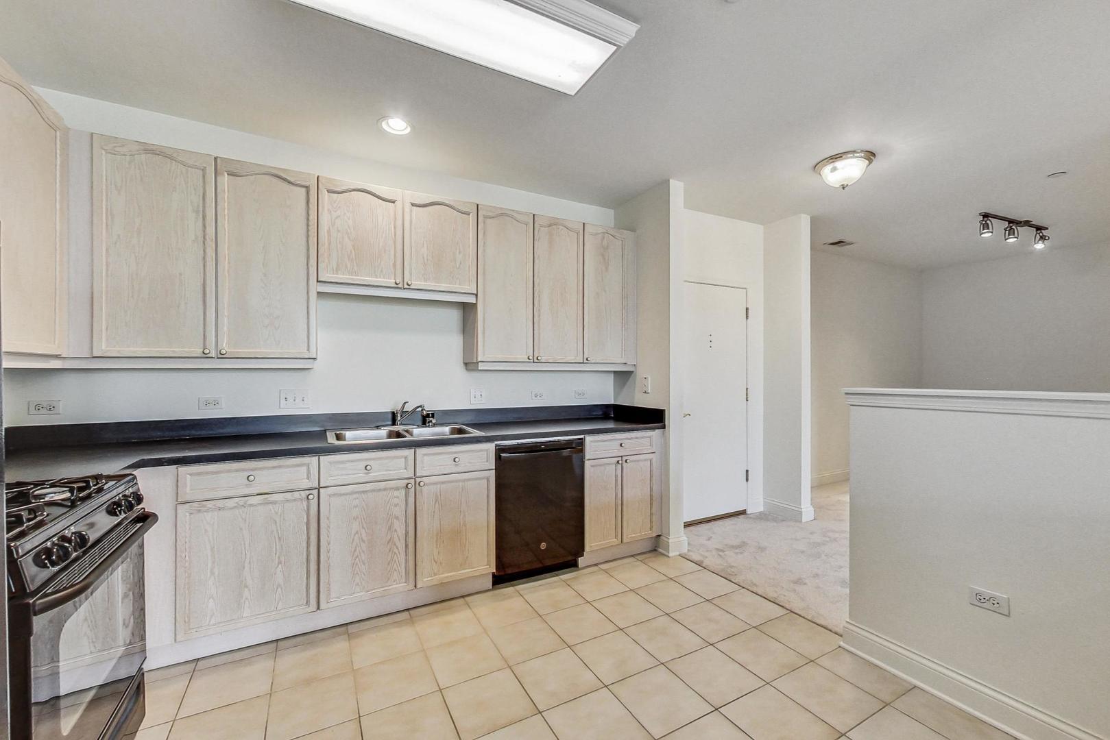 620 McHenry Road, Unit 407 Wheeling, IL 60090 - Photo 8 of 23 a kitchen with granite countertop white cabinets and stainless steel appliances