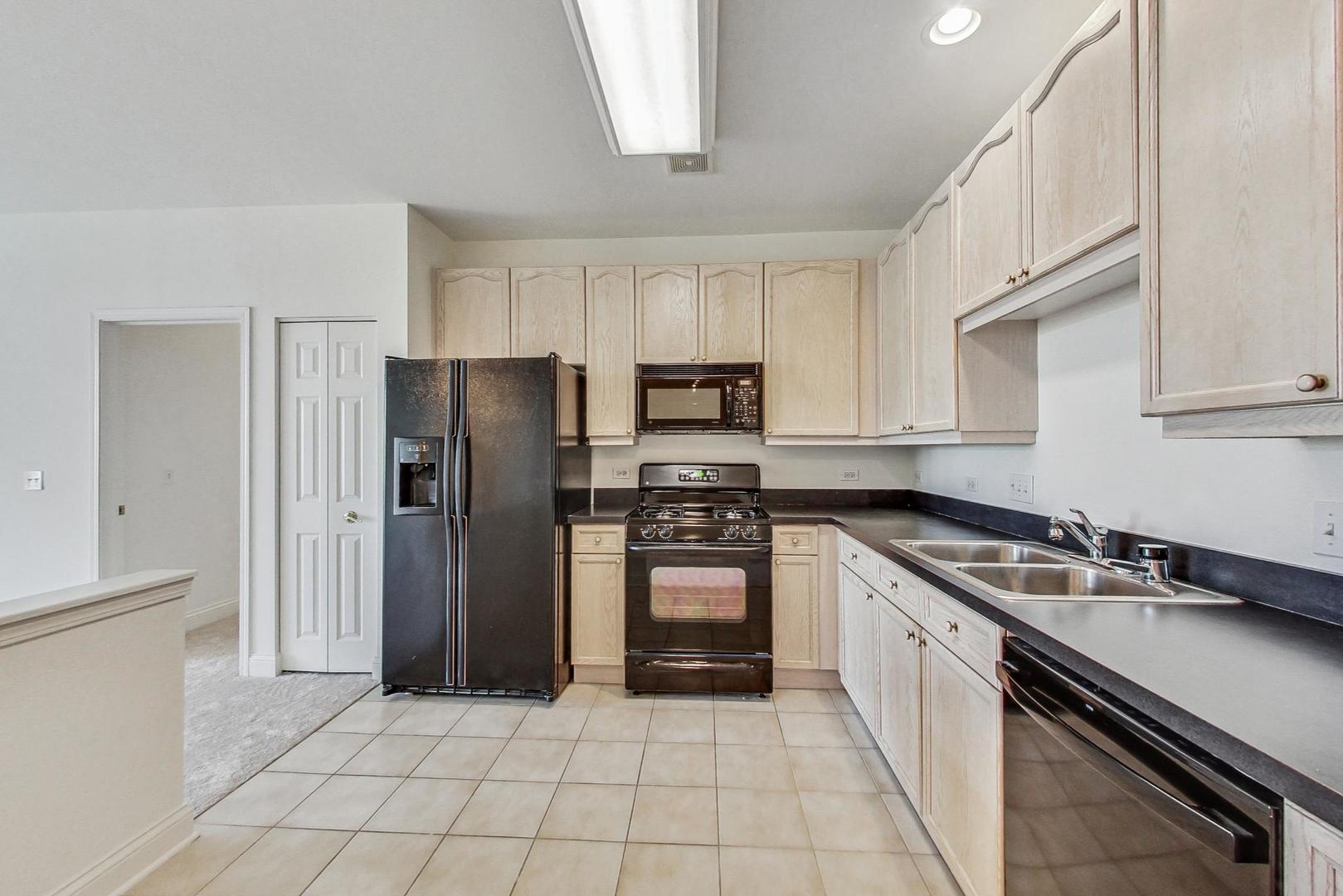 620 McHenry Road, Unit 407 Wheeling, IL 60090 - Photo 9 of 23 a kitchen with stainless steel appliances granite countertop a refrigerator and a sink