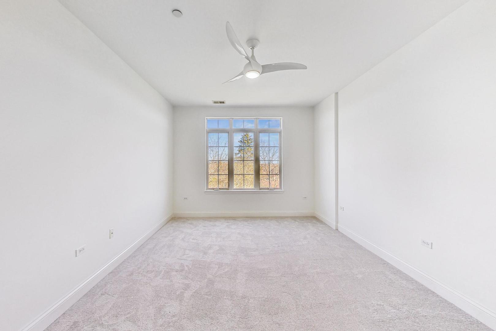 620 McHenry Road, Unit 407 Wheeling, IL 60090 - Photo 10 of 23 an empty room with windows and ceiling fan