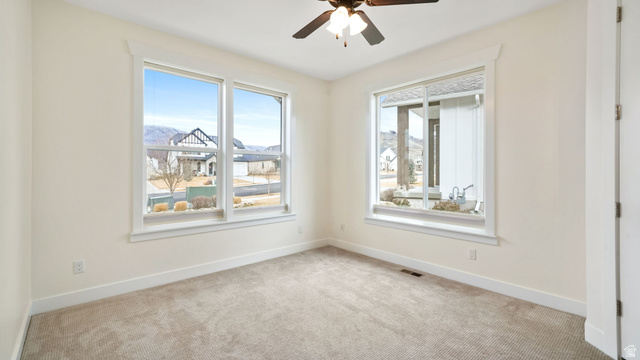 1238 Canyon View Road Midway, UT 84049 - Photo 15 of 36 Bright room featuring two windows, neutral carpeting, and a ceiling fan with integrated lighting