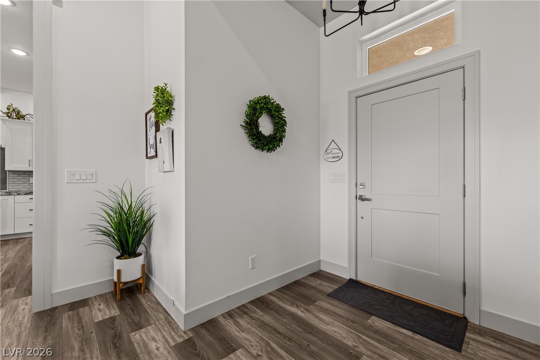 3020 Hannig Street Logandale, NV 89021 - Photo 30 of 75 A welcoming entryway with rich wood-look flooring leads to a brightly lit kitchen.
