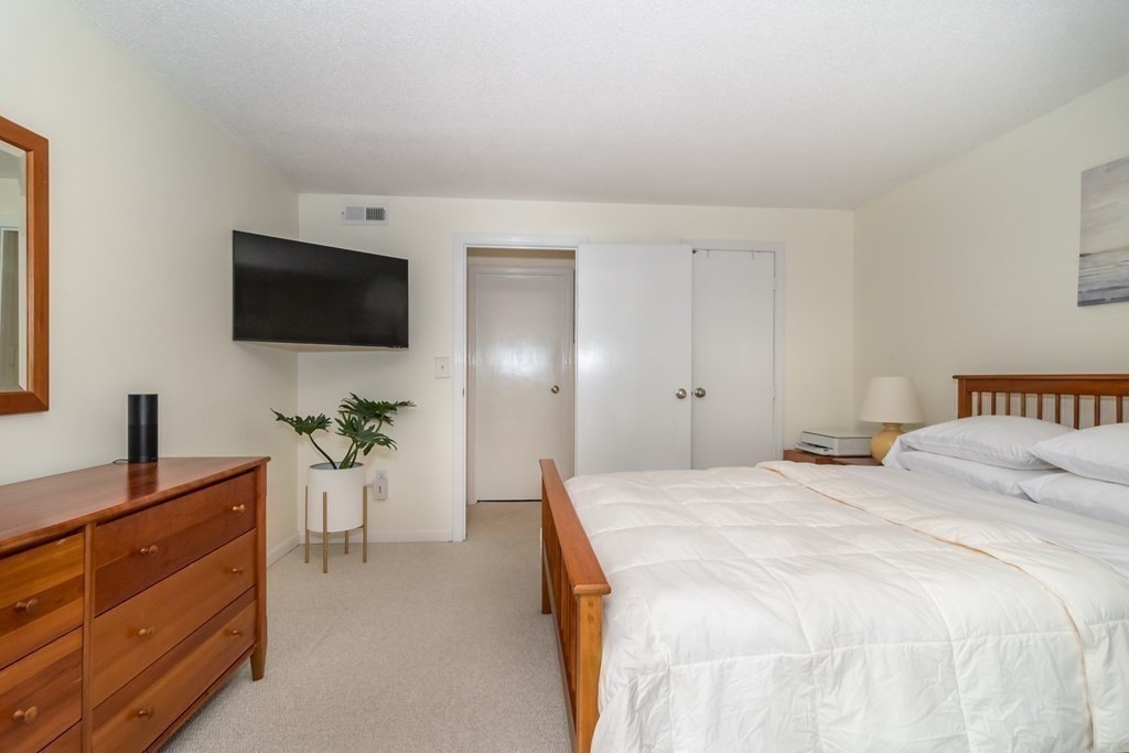 30 Walden Drive, Unit 7 Natick, MA 01760 - Photo 13 of 18 a bedroom with a bed and a flat screen tv