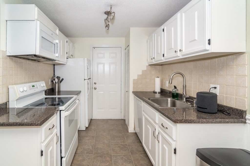 30 Walden Drive, Unit 7 Natick, MA 01760 - Photo 8 of 18 a kitchen with stainless steel appliances granite countertop a sink stove and refrigerator