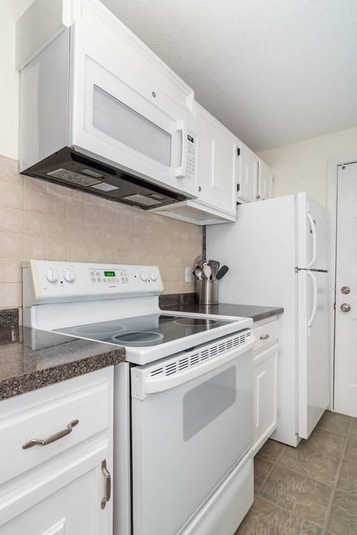 30 Walden Drive, Unit 7 Natick, MA 01760 - Photo 9 of 18 a view of cabinets a washer and dryer