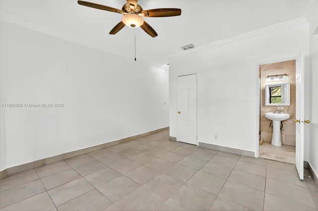 an empty room with closet and a chandelier fan