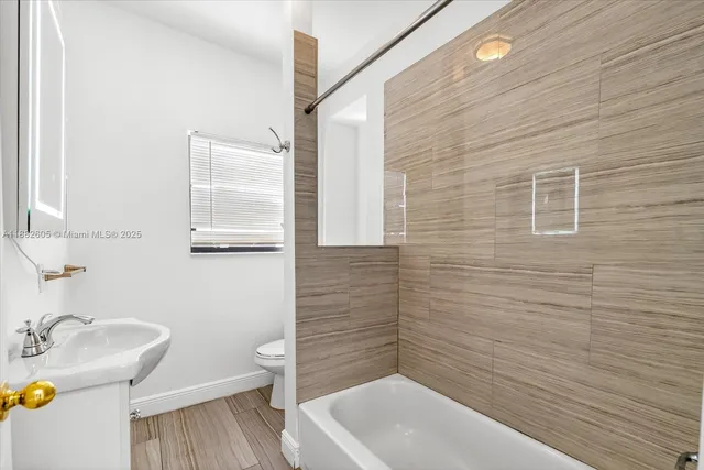 a bathroom with a sink a toilet and bathtub