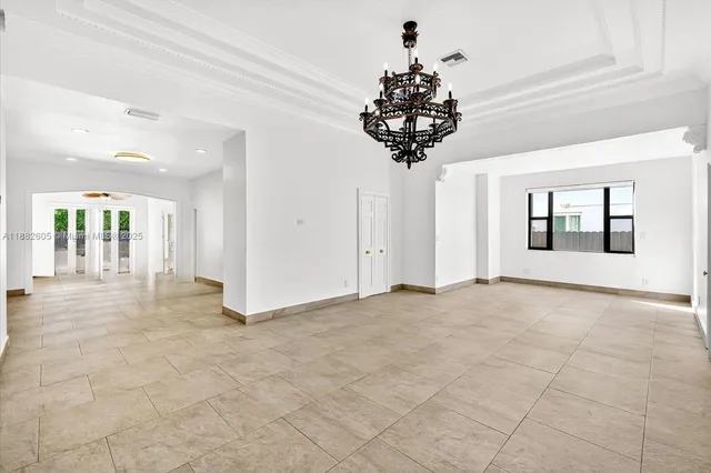 a view of an empty room and chandelier