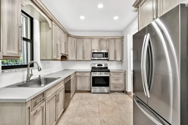 a kitchen with stainless steel appliances granite countertop a sink stove and refrigerator