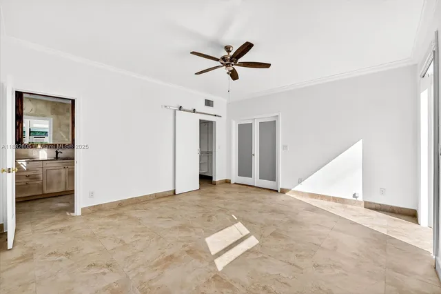 a view of a livingroom with a ceiling fan and kitchen space
