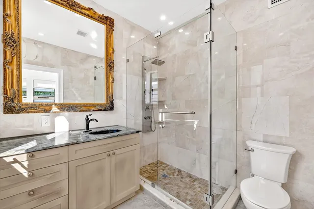 a bathroom with a sink a toilet and shower