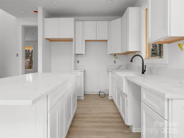 a kitchen with kitchen island granite countertop a sink and cabinets