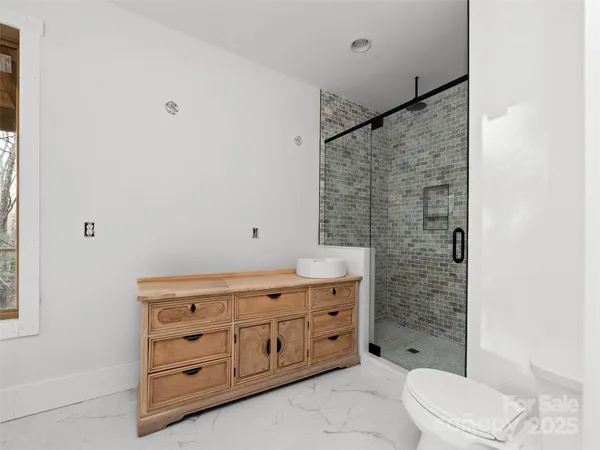 a bathroom with a sink a toilet and shower