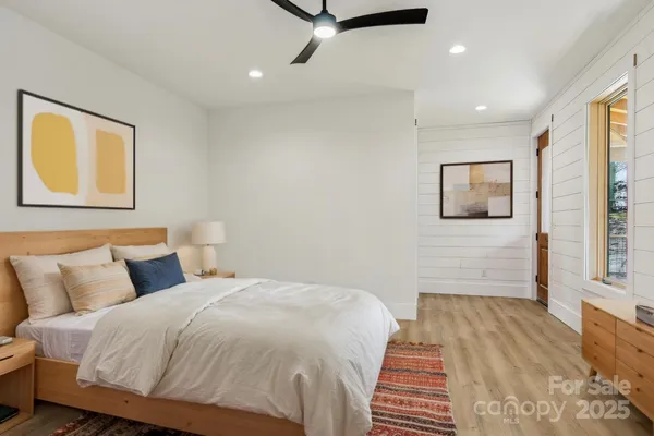 a bedroom with a large bed and a chandelier