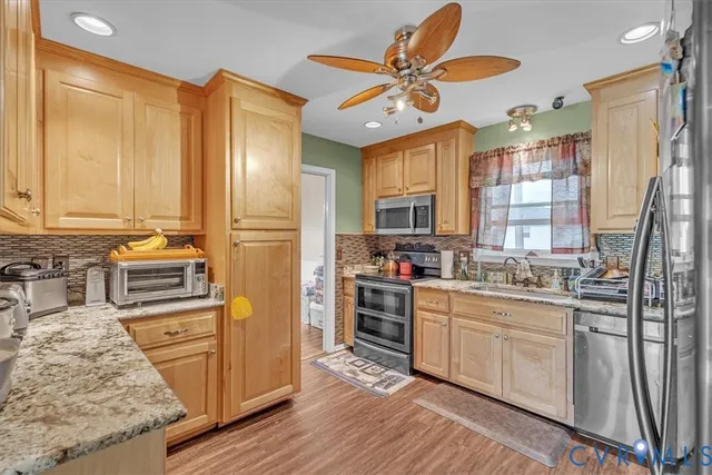 a kitchen with stainless steel appliances granite countertop a stove a sink dishwasher and a refrigerator