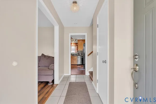 a view of a hallway to a livingroom with furniture and windows