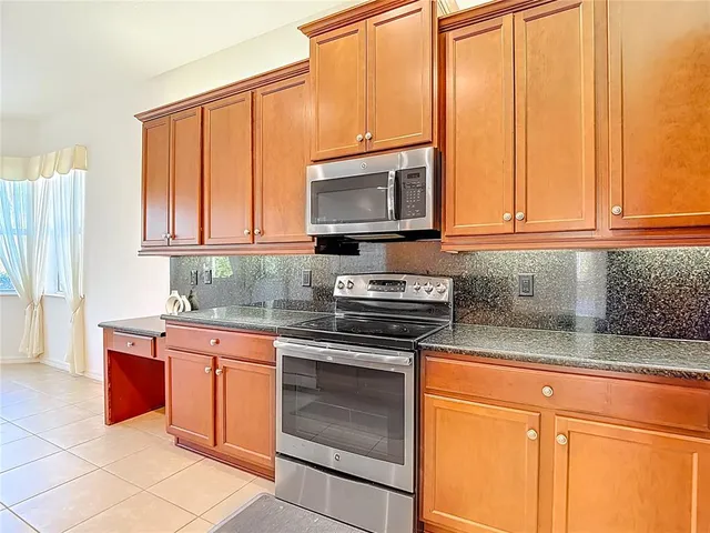 an empty room with wooden floor cabinet and windows