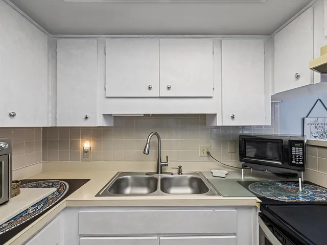 a kitchen with white cabinets and a sink