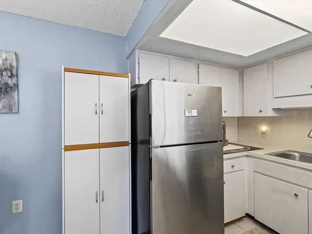 a white refrigerator freezer and a stove in a kitchen