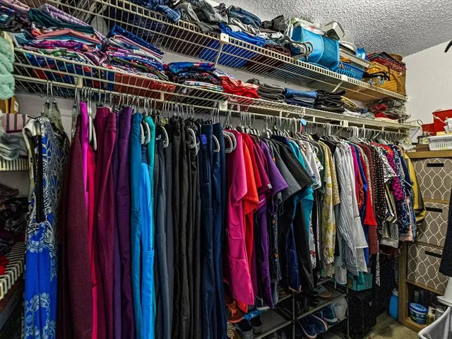 a view of walk in closet with clothes