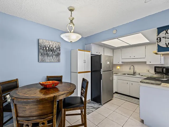 a kitchen with stainless steel appliances a table chairs and refrigerator