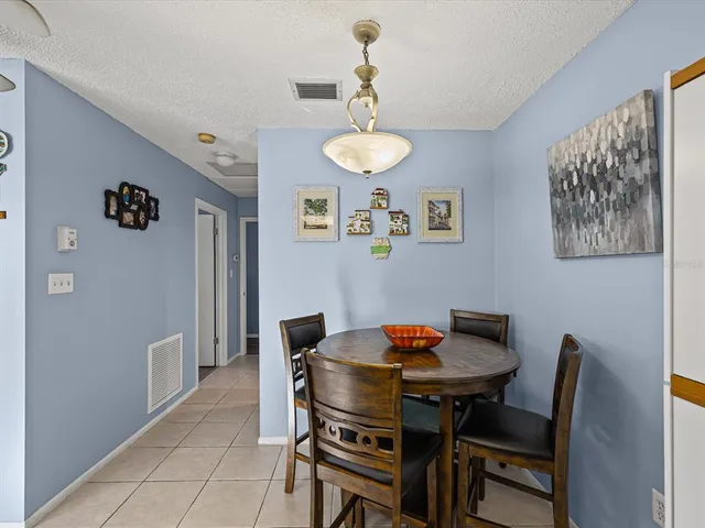 a view of a dining room with furniture and a chandelier fan