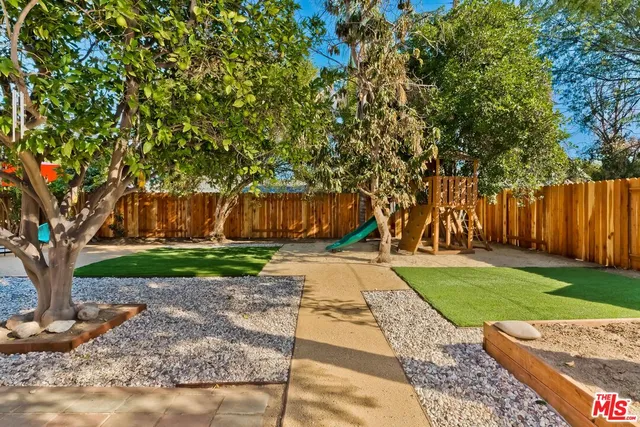 a view of a yard with plants and trees