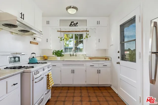 a kitchen with a stove a sink and a refrigerator