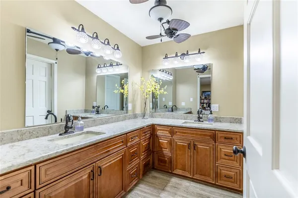 a bathroom with a granite countertop sink a large mirror and shower