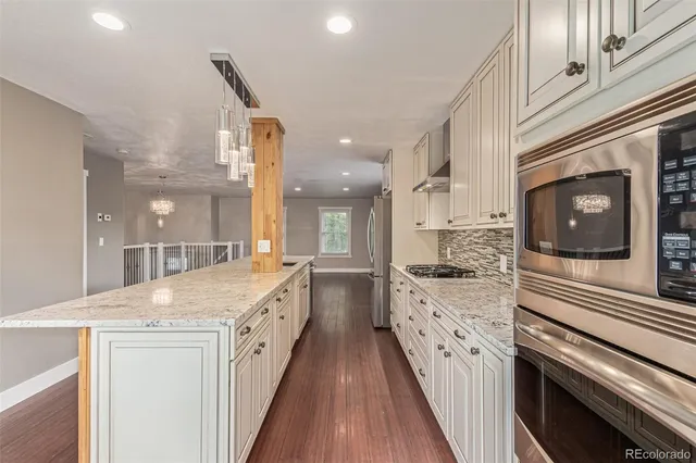 a large kitchen with a large counter space a sink and stainless steel appliances
