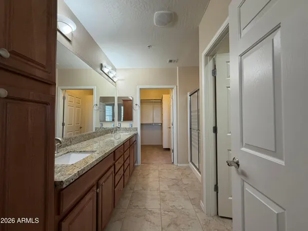 a bathroom with a glass shower door and a sink