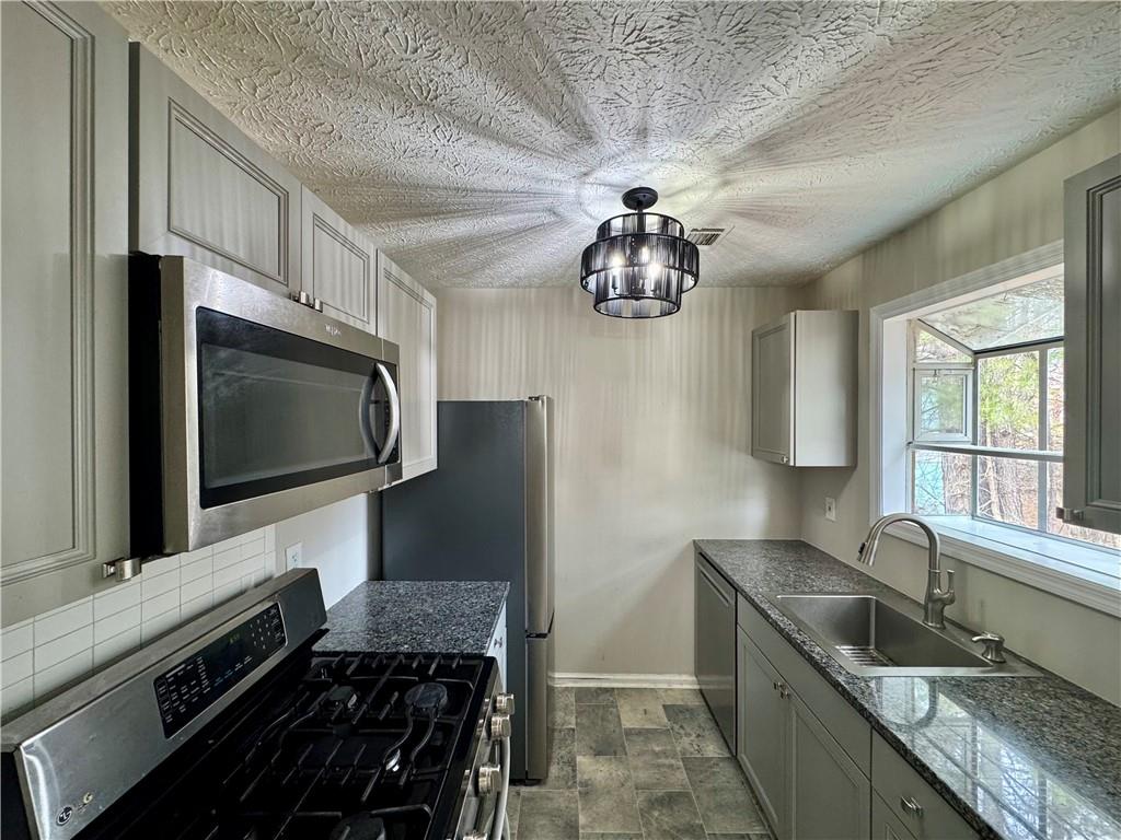 4922 Windsor Downs Lane Decatur, GA 30035 - Photo 11 of 23 a kitchen with stainless steel appliances granite countertop a sink stove and microwave