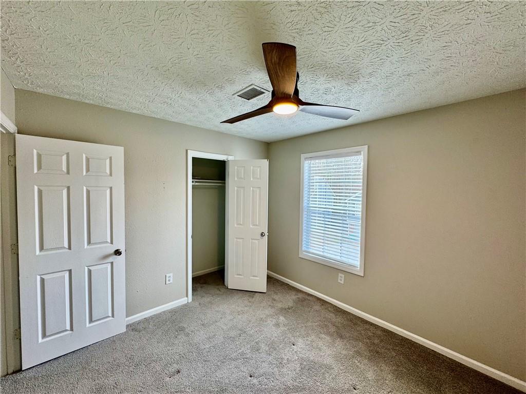 4922 Windsor Downs Lane Decatur, GA 30035 - Photo 14 of 23 a view of an empty room with window and chandelier fan
